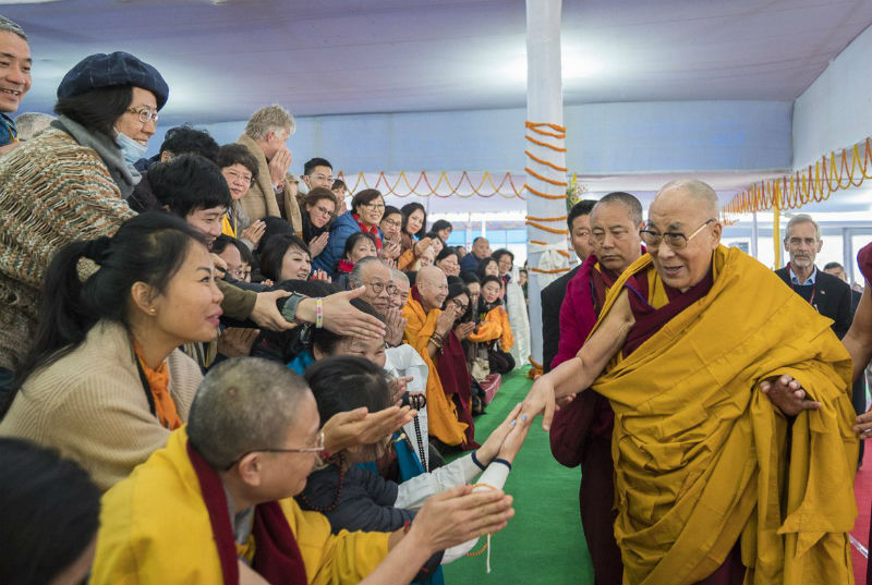 His Holiness the Dalai Lama greeting members of the audience as he arrives at the Kalachakra Maidan for the Solitary Hero Vajrabhairava Empowerment in Bodhgaya, Bihar, India on January 21, 2018. Photo: Lobsang Tsering