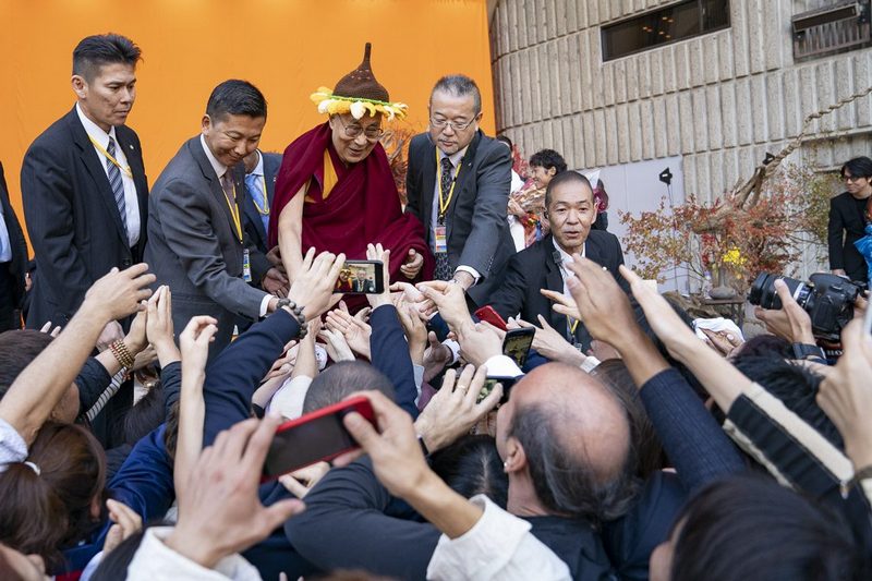 His Holiness the Dalai Lama reaching out to touch the hands of members of the audience at the conclusion of his talk at the Hibiya Open Air Concert Hall in Tokyo, Japan on November 17, 2018. Photo by Tenzin Choejor